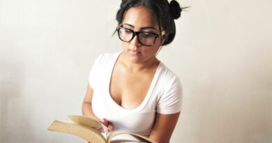 a woman wearing glasses is reading a book