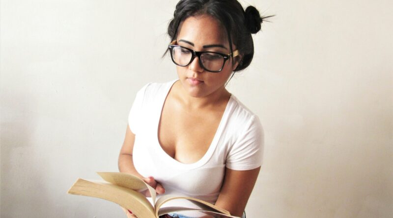 a woman wearing glasses is reading a book