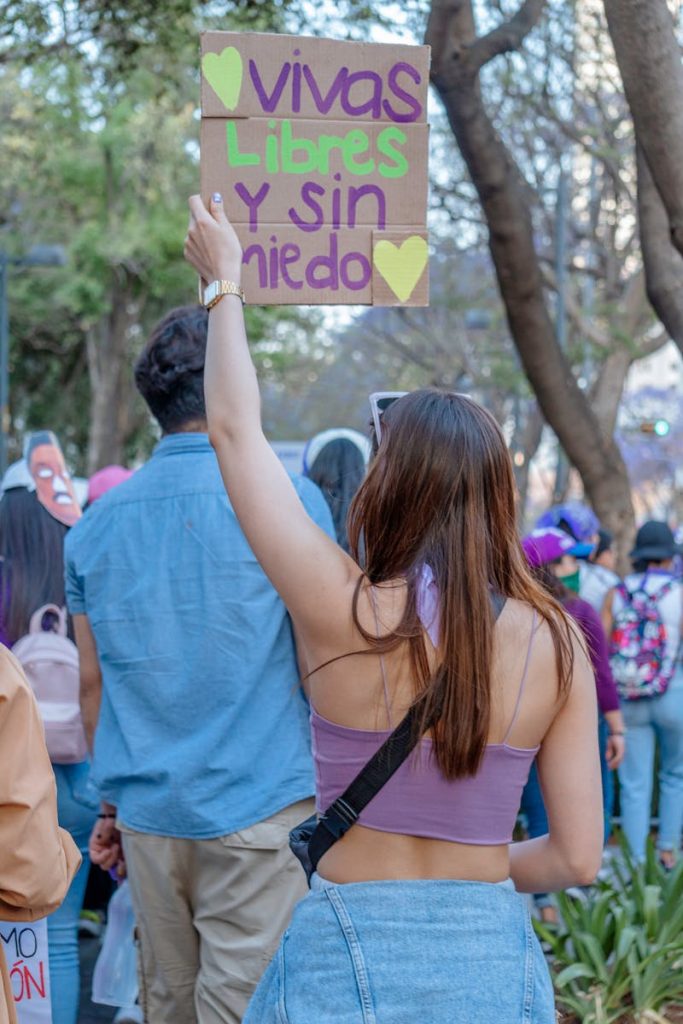 Woman holding a sign during a women's protest in Mexico City advocating for empowerment. Violencia machista. Sanar